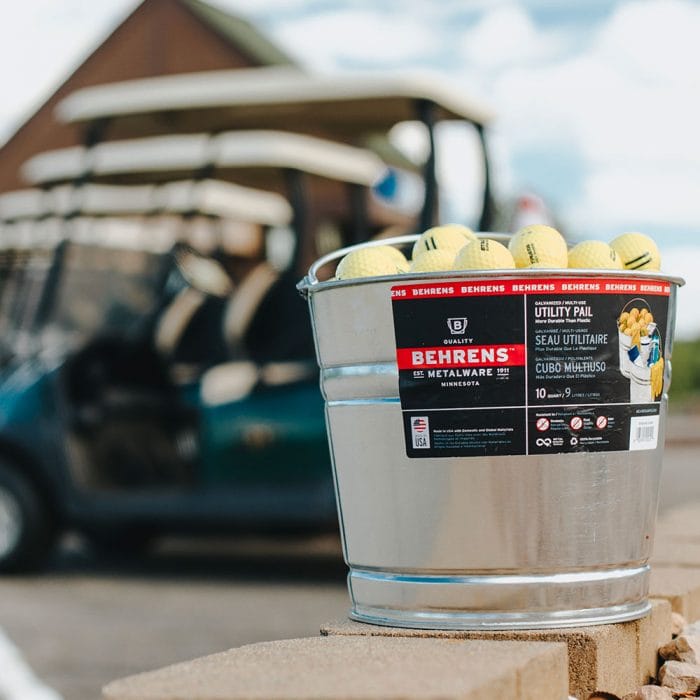 Behrens Metalware Classics Galvanized Steel Pail filled with golf balls with a golf cart in the back ground