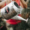 woman using Hot Dipped Galvanized Steel Watering Can to water her plants