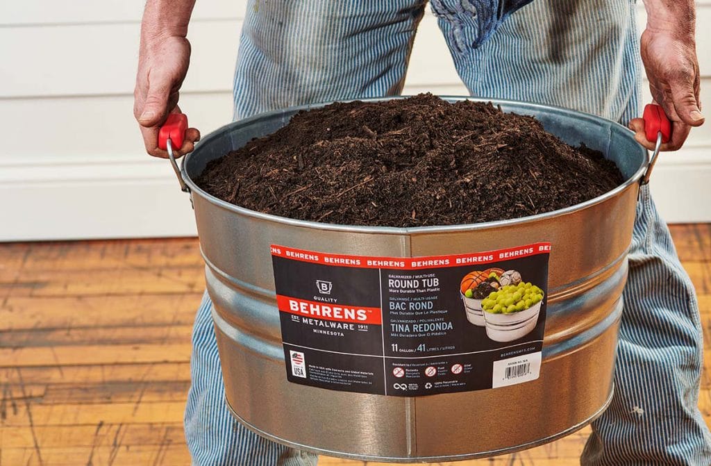 man caryying a heavy tub with red comfort grip handles