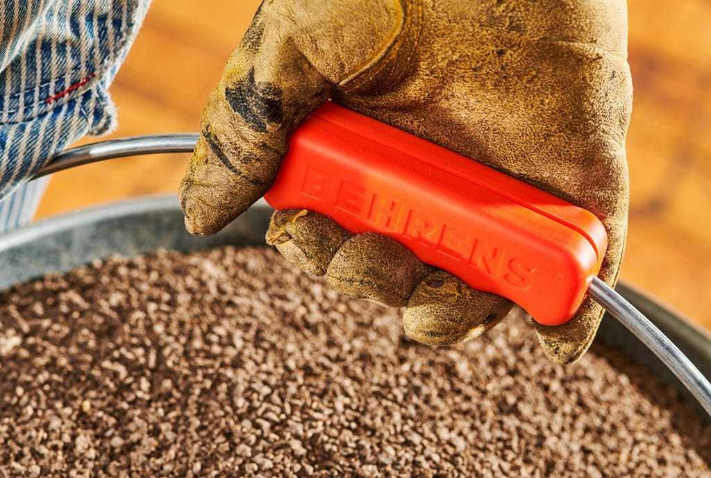 man carrying behrens pail with orange comfort grip on handle